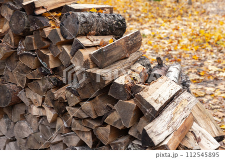Pile of old firewood, birch chocks lay stacked 112545895