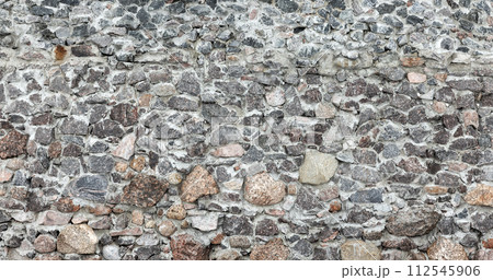 Gray stone wall of an ancient fortress, background photo texture 112545906