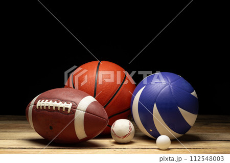 Set of various sport balls on wooden floor on black background 112548003