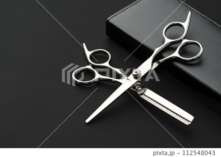 Hairdressing scissors with case on a black background 112548043