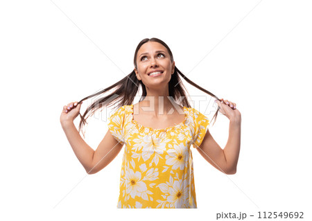 young pretty woman with straight black hair in a yellow sundress with a print pattern is happy young pretty woman with straight black hair in a yellow sundress with a print pattern is happy 112549692