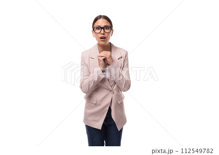 slim smart young woman with black hair and glasses for vision is dressed in a beige jacket and jeans 112549782