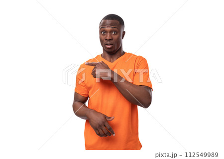 young american man dressed in basic orange t-shirt having doubts and suspicion on white background 112549989