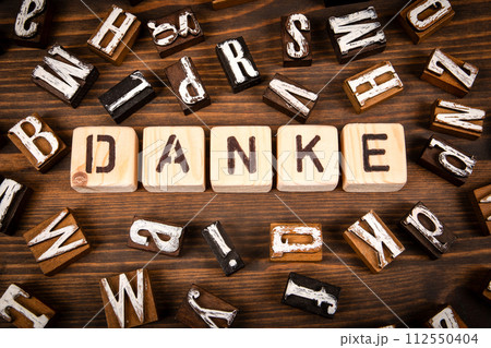 Thank you in German. Alphabet blocks on wood texture background Thank you in German. Alphabet blocks on wood texture background 112550404