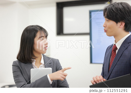 立って打ち合わせ_間違いを指摘するビジネスウーマン_1 112551291