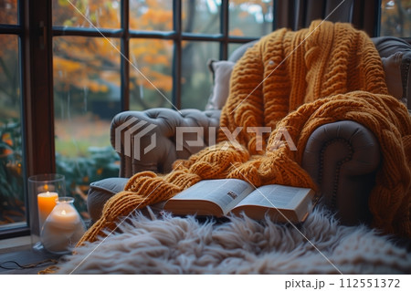 AI-generated content. Cozy autumn reading nook with candle and throw AI-generated content. Cozy autumn reading nook with candle and throw 112551372