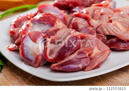 Raw chicken gizzards on wooden table 112551623