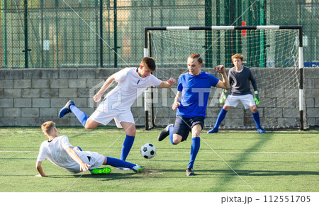 Youthful football players challenging for ball 112551705