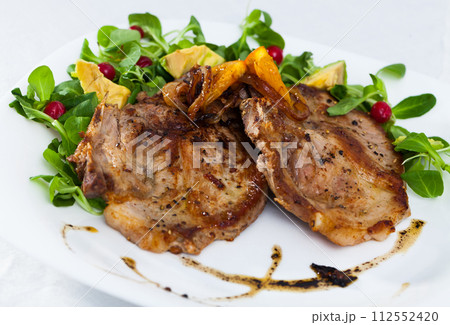 Pork chop, salad with avocado and berries 112552420