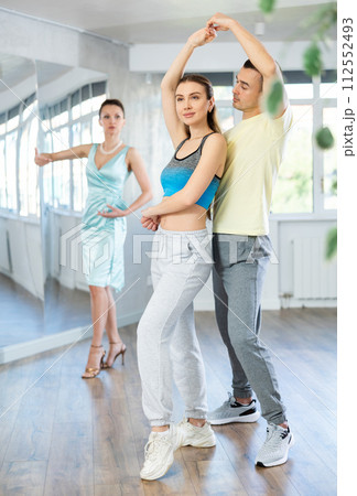 Positive man and woman practicing samba in dance class 112552493