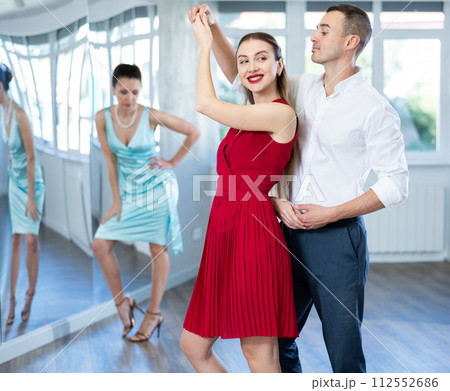 Couple in stage costumes learns boogie woogie dancing during individual lesson 112552686
