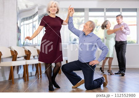 Senior man and elderly woman are dancing contemporary discofox in couple 112552980