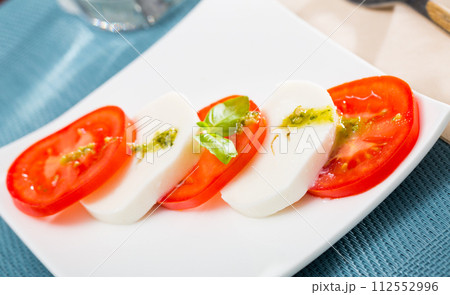 Salad caprese with tomatoes, mozzarella cheese and herbs Salad caprese with tomatoes, mozzarella cheese and herbs 112552996