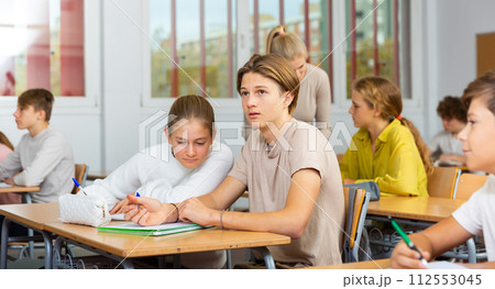 Teenage girls and boys exercising during lesson in school 112553045