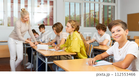 Young boy sitting at desk in classroom Young boy sitting at desk in classroom 112553466
