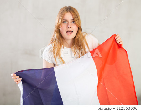 Young happy woman holding flag of French with happy face and smiling 112553606