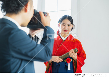 袴の女性の写真を撮る男性 袴の女性の写真を撮る男性 112553608