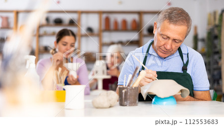 elderly potter is working with clay billet elderly potter is working with clay billet 112553683