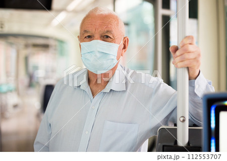 Elderly man standing in tram 112553707