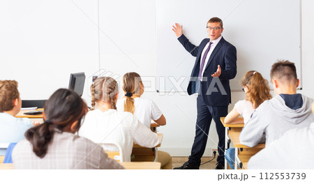 Male teacher lecturing to students at classroom 112553739