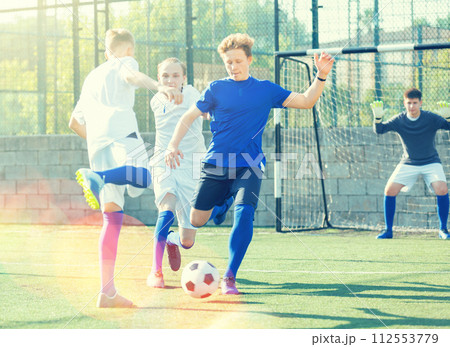 Teens playing soccer football match. Competition between two youth soccer teams Teens playing soccer football match. Competition between two youth soccer teams 112553779