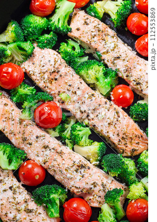 One pan dish baked salmon fillet with broccoli and tomato, vertical, top view, closeup 112553869