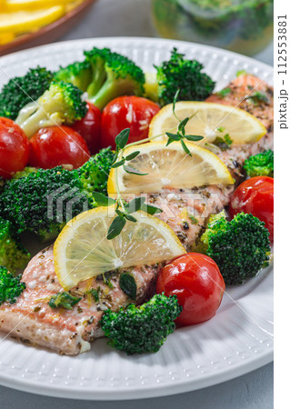 Baked salmon fillet with broccoli and tomato, salmon steak with vegetables, vertical, closeup 112553881