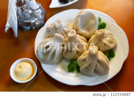 Khinkali, Georgian dumplings with sauce and parsley 112554087