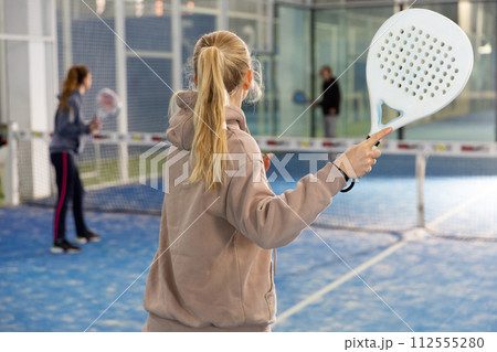 Padel players, woman playing match on court at fitness center 112555280