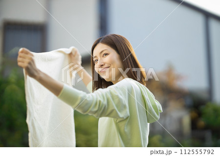 洗濯物を持つミドルの女性 112555792