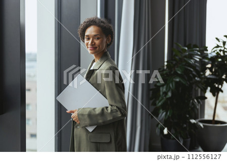 Woman with paper by window in formal wear, interior design event Woman with paper by window in formal wear, interior design event 112556127