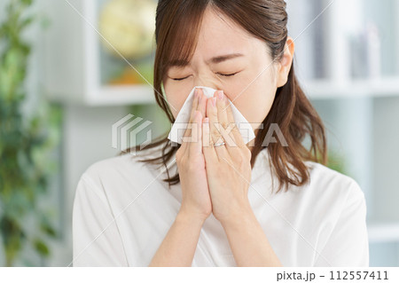 鼻炎で鼻をかむ女性 112557411