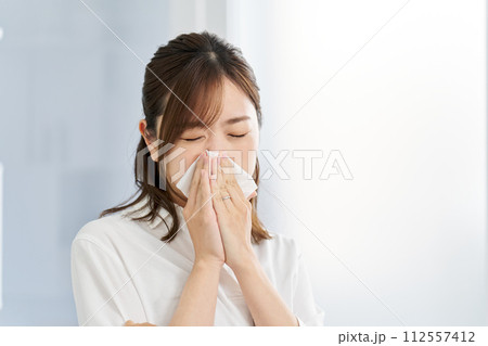 鼻炎で鼻をかむ女性 112557412