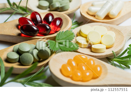 スプーンの上にカラフルなサプリメント　ヘルスケアのイメージ素材 112557551