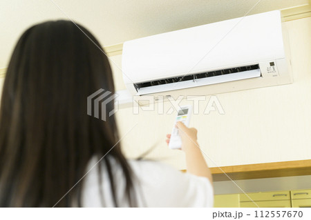 エアコンを操作する女性（エアコン本体にピント） 112557670
