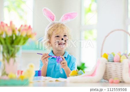 Kids on Easter egg hunt. Children dye eggs. 112559508