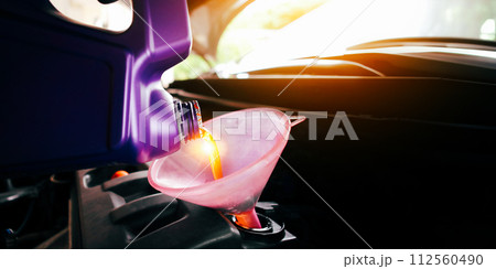 Engine oil poured into a funnel in the engine oil filler with copy space Engine oil poured into a funnel in the engine oil filler with copy space 112560490