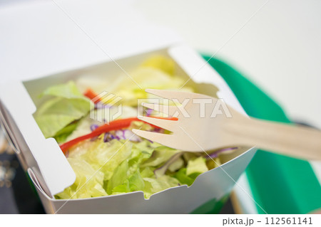 木製スプーンと紙容器とサラダ 112561141
