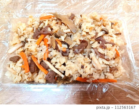 使い捨て容器に詰めた炊き込みごはん 112563167