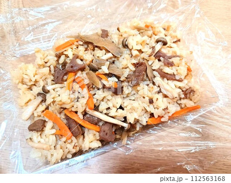 使い捨て容器に詰めた炊き込みごはん 112563168