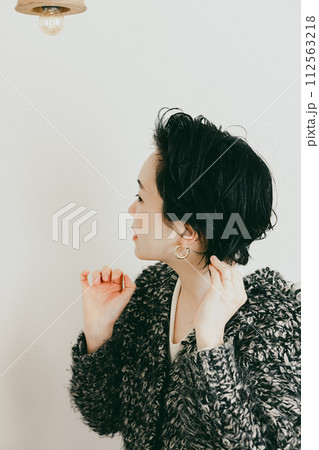 髪をセットするショートカットのおしゃれな女性 112563218
