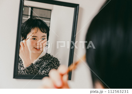 髪をセットするショートカットのおしゃれな女性 112563231