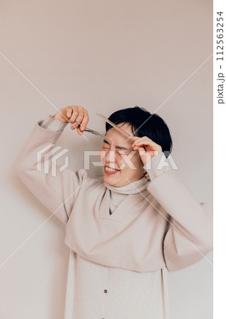 セルフヘアカットをするショートカットのおしゃれな女性 セルフヘアカットをするショートカットのおしゃれな女性 112563254