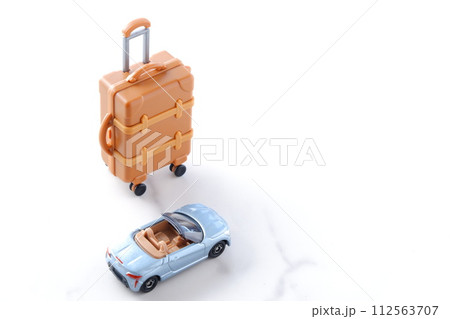 ふたり乗りのオープンカーとスーツケースで、ドライブ旅行へ出発するイメージ 112563707