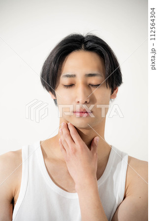自分の顔を触る若い男性 112564304