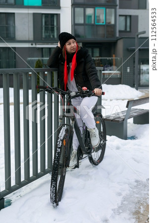 A woman rented a bicycle to ride around the city in winter. A woman rented a bicycle to ride around the city in winter. 112564533