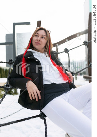 Happy woman spends weekend walking on outdoor entertainment area in winter Happy woman spends weekend walking on outdoor entertainment area in winter 112564534
