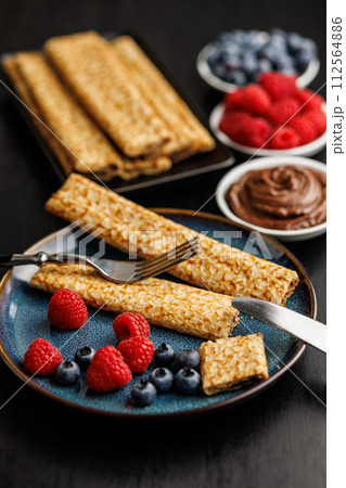 Delicate crepes stacked with blueberries and raspberries, served with a chocolate spread. Delicate crepes stacked with blueberries and raspberries, served with a chocolate spread. 112564886
