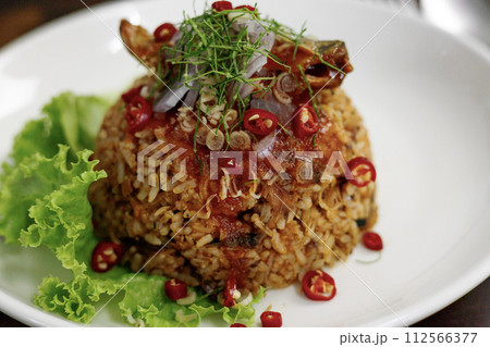 Thai food, Fried jasmine rice with canned fish mackerel in tomato sauce, topped with red chili, red onion, lettuce and kaffir lime leaves. Thai food, Fried jasmine rice with canned fish mackerel in tomato sauce, topped with red chili, red onion, lettuce and kaffir lime leaves. 112566377