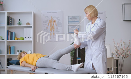 A doctor evaluates a patient suffering from joint inflammation, providing arthritis treatment A doctor evaluates a patient suffering from joint inflammation, providing arthritis treatment 112567166